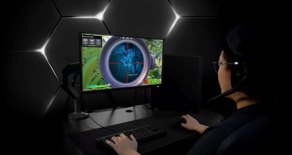 Gamer playing on computer, behind is a dark background with few lights.